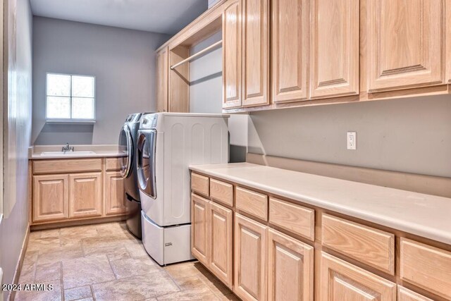 7101 E Berneil Ln, Paradise Valley, AZ 85253 - laundry room featuring cabinet space, light stone finish flooring, and washing machine and dryer