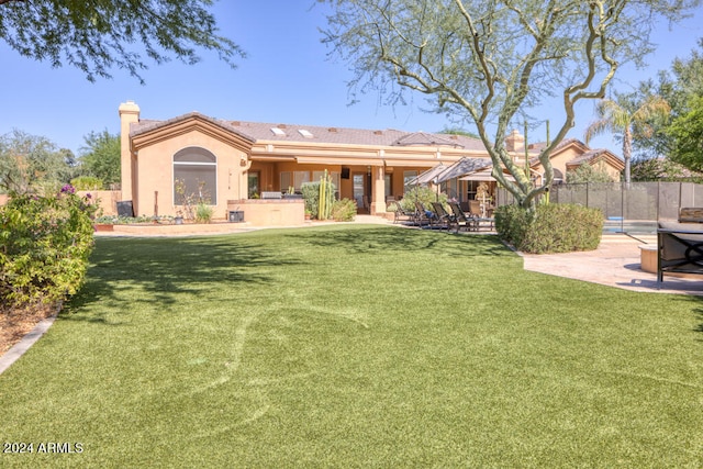 back of house featuring a lawn and a patio area