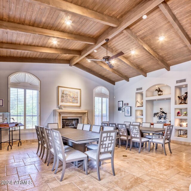 7101 E Berneil Ln, Paradise Valley, AZ 85253 - dining space featuring stone tile flooring, built in features, ceiling fan, wooden ceiling, and a glass covered fireplace