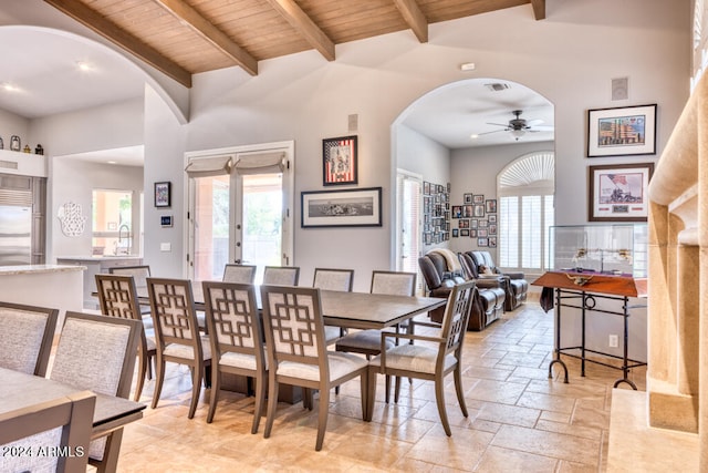 dining room with wooden ceiling, beam ceiling, ceiling fan, and high vaulted ceiling