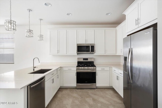 kitchen with appliances with stainless steel finishes, sink, kitchen peninsula, decorative light fixtures, and white cabinets