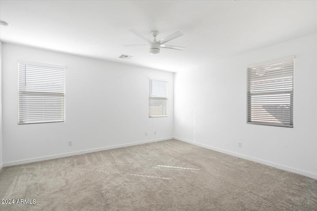 carpeted spare room featuring ceiling fan