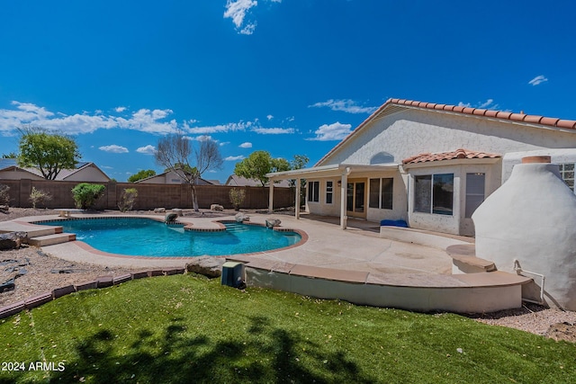 view of swimming pool featuring a patio, a fenced backyard, a diving board, a yard, and a fenced in pool