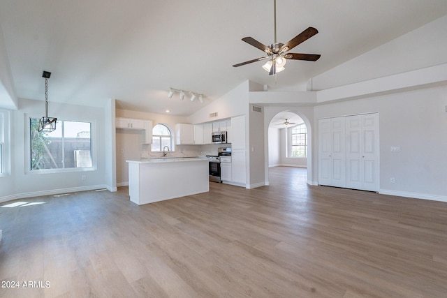 unfurnished living room featuring a wealth of natural light, light wood-style flooring, and a ceiling fan