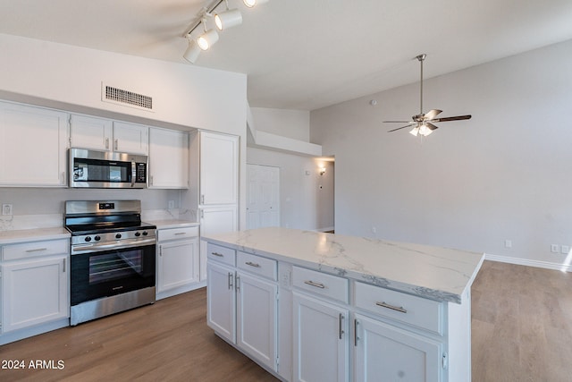 kitchen featuring stainless steel appliances, ceiling fan, white cabinets, and light hardwood / wood-style flooring