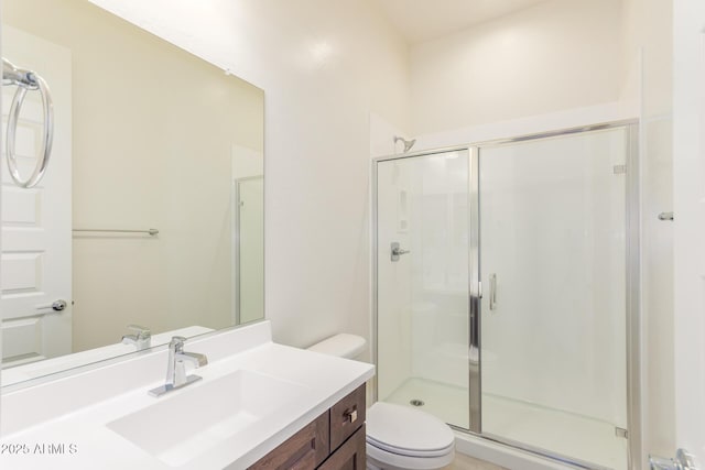 bathroom with vanity, toilet, and a shower with door