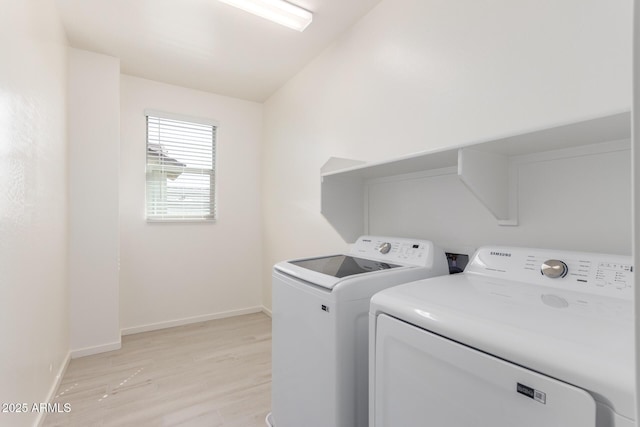 laundry area with washer and dryer and light wood-type flooring