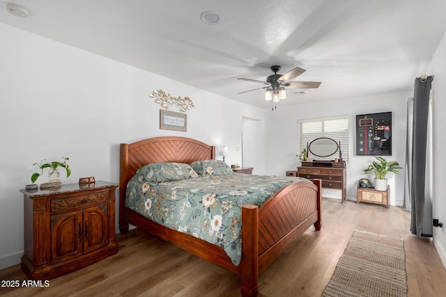 bedroom with light wood-style floors, ceiling fan, and baseboards