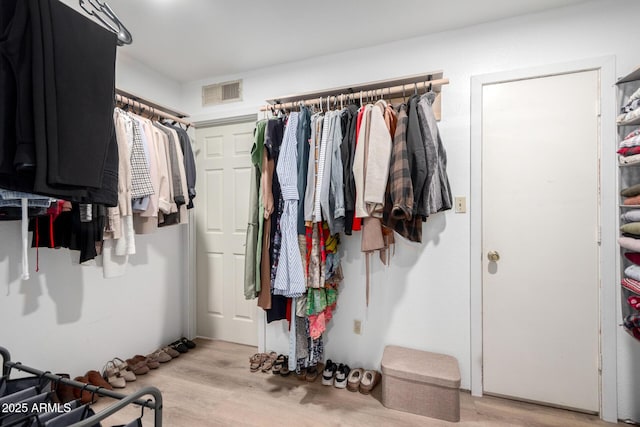 walk in closet with light wood-style flooring and visible vents