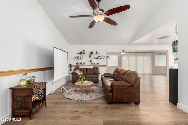 living room with vaulted ceiling, wood finished floors, and visible vents