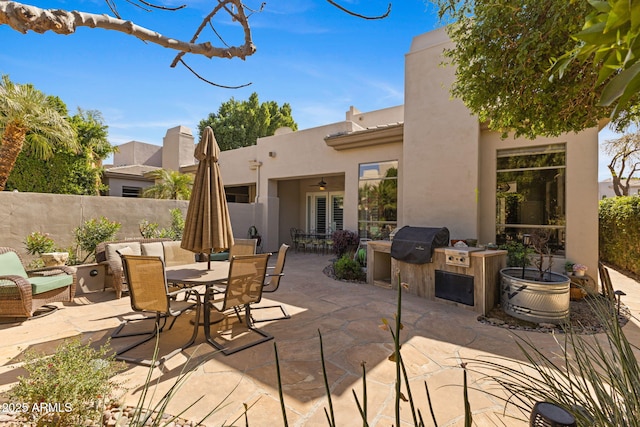 view of patio with outdoor dining space, fence, and area for grilling