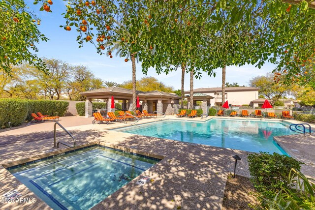 community pool with a community hot tub, a patio area, and fence