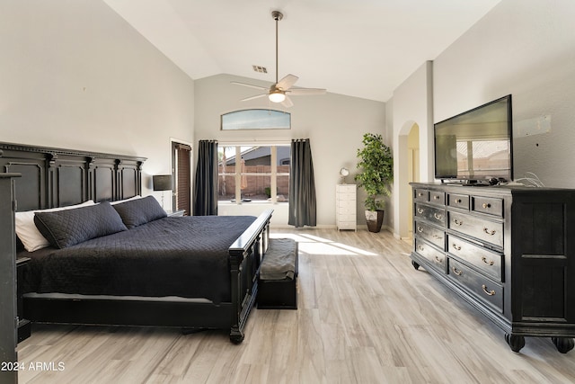 bedroom featuring light hardwood / wood-style floors, lofted ceiling, multiple windows, and ceiling fan