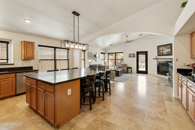 kitchen with a kitchen bar, decorative light fixtures, lofted ceiling, a center island, and dishwasher