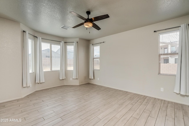 empty room featuring ceiling fan, a textured ceiling, and light wood-type flooring