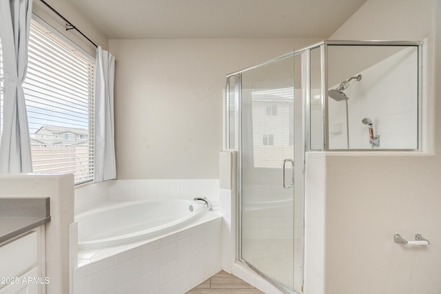 bathroom featuring vanity, independent shower and bath, and a wealth of natural light