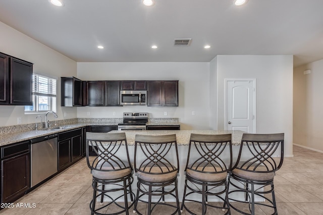 kitchen featuring appliances with stainless steel finishes, a center island, sink, and a kitchen breakfast bar