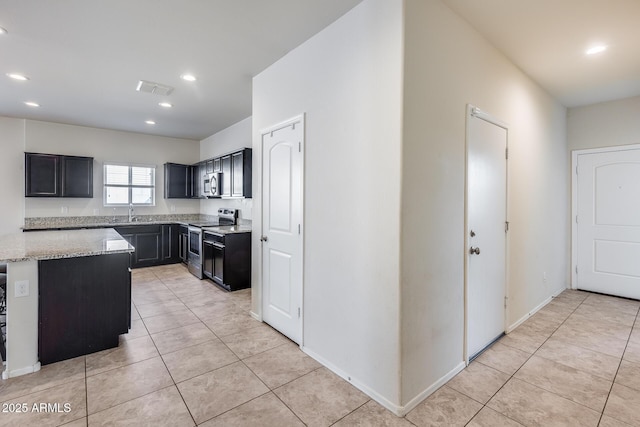 kitchen featuring stainless steel appliances, light stone countertops, and light tile patterned floors