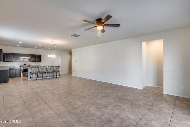 unfurnished living room with ceiling fan with notable chandelier and light tile patterned floors