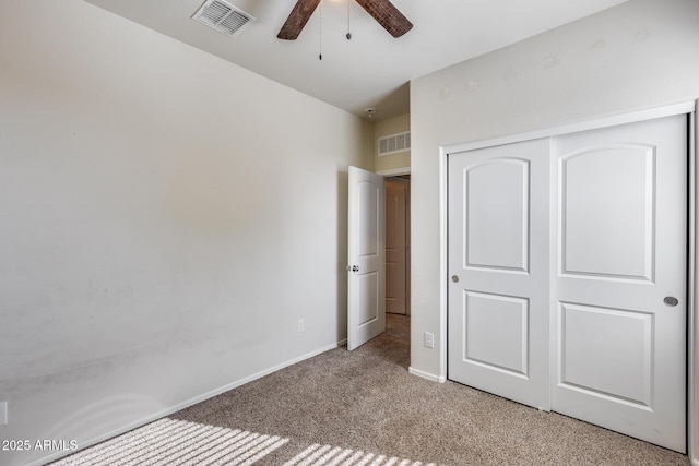 unfurnished bedroom featuring ceiling fan, a closet, and light carpet