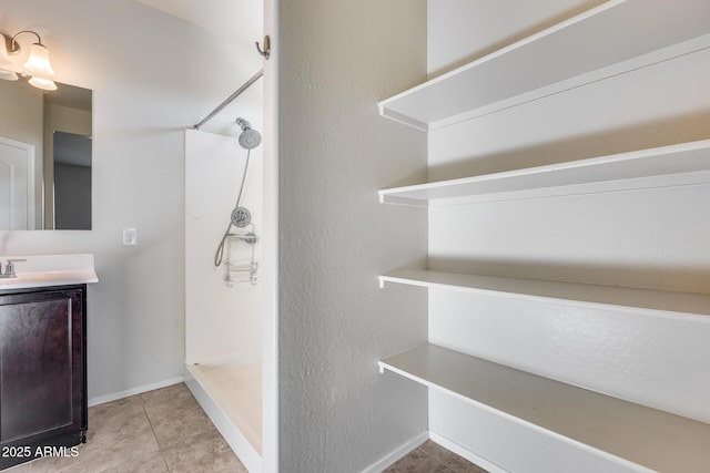 bathroom featuring vanity, tile patterned floors, and a shower