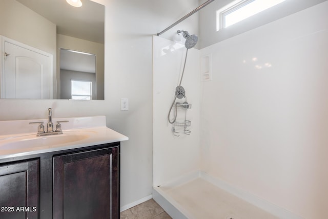 bathroom featuring tile patterned flooring, vanity, and a shower