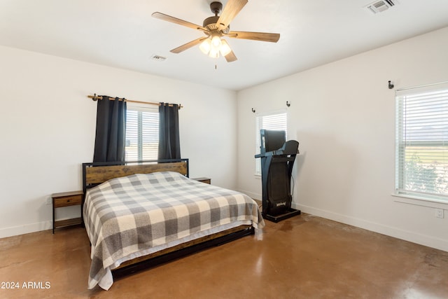 bedroom featuring concrete flooring, multiple windows, and ceiling fan