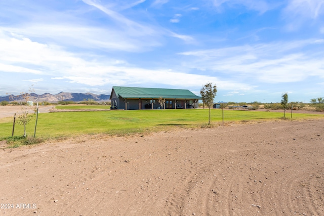 view of front of house featuring a mountain view, a rural view, and a front lawn