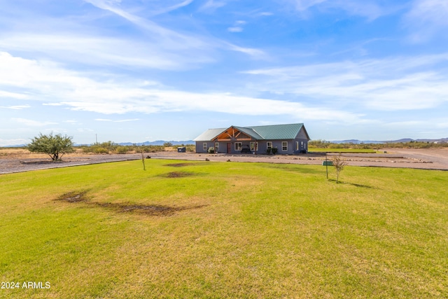 view of front of house with a rural view and a front yard