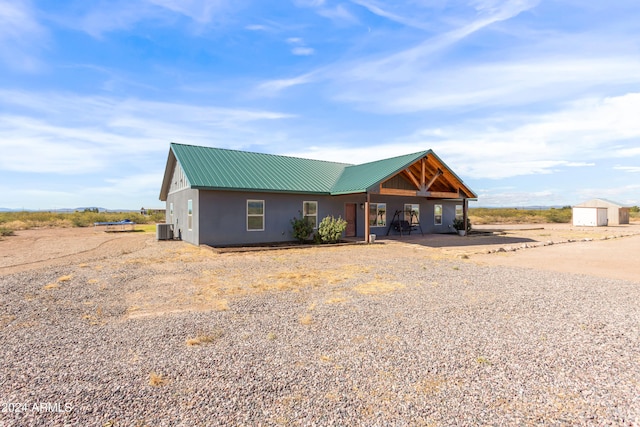 view of front of property featuring a storage unit and central AC