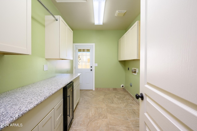 laundry room with wine cooler, hookup for a washing machine, electric dryer hookup, and cabinets