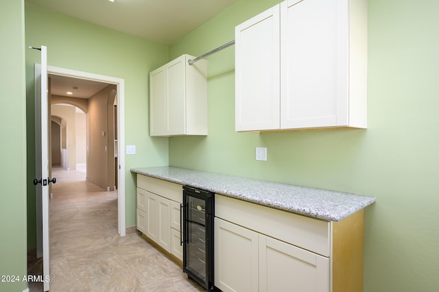 interior space featuring beverage cooler, arched walkways, and baseboards