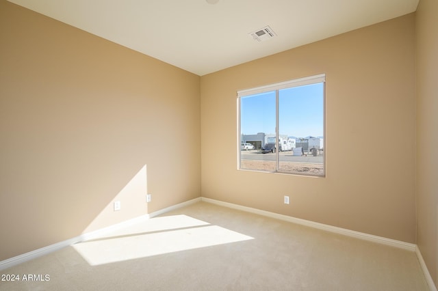 carpeted empty room with visible vents and baseboards