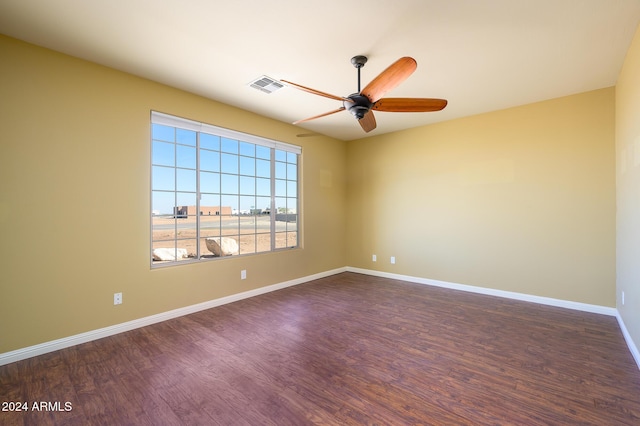 unfurnished room with baseboards, a ceiling fan, dark wood-style flooring, and visible vents