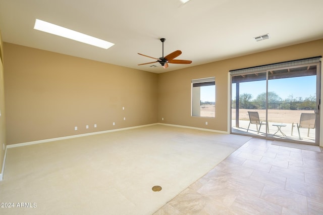 spare room with visible vents, a ceiling fan, baseboards, and light carpet