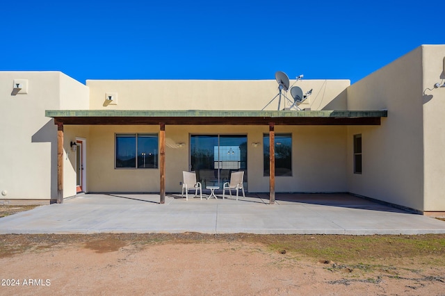back of property featuring a patio and stucco siding