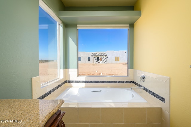 bathroom featuring vanity and tiled bath