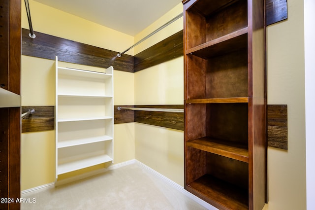 walk in closet featuring light carpet