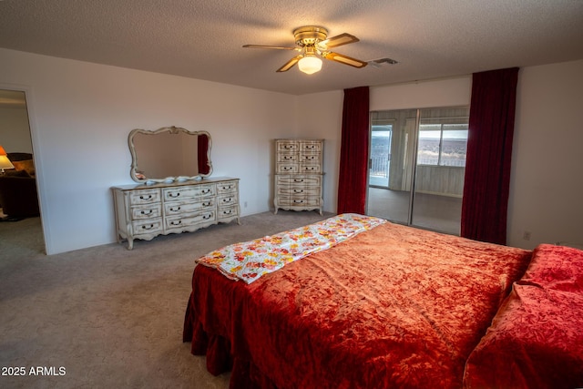 carpeted bedroom featuring a textured ceiling and ceiling fan