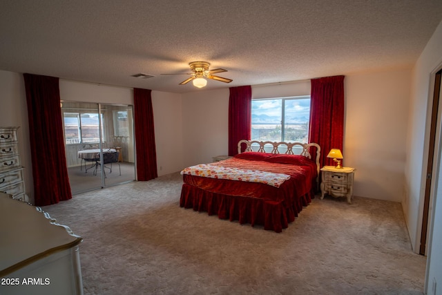 bedroom featuring a textured ceiling, ceiling fan, light carpet, and multiple windows