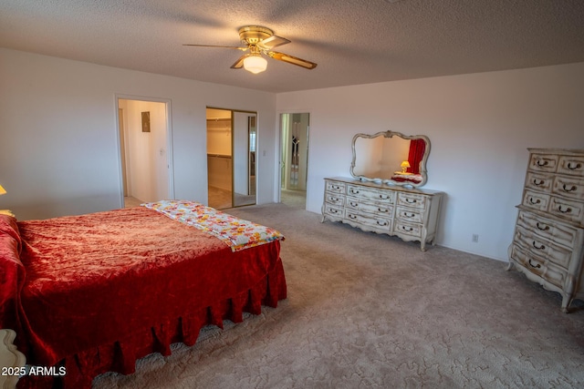 carpeted bedroom with a textured ceiling, a closet, a spacious closet, and ceiling fan