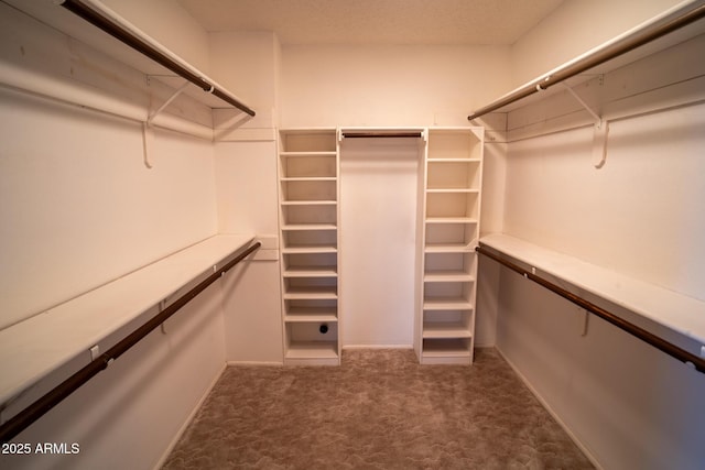 walk in closet with dark carpet