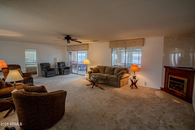 carpeted living room with ceiling fan and a textured ceiling