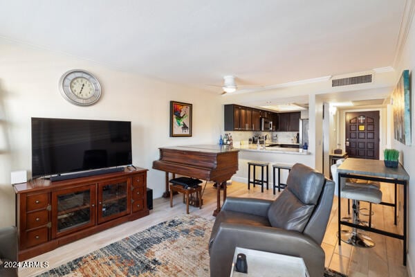 living room with light hardwood / wood-style floors and ceiling fan