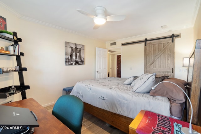 bedroom featuring crown molding, wood-type flooring, a barn door, and ceiling fan