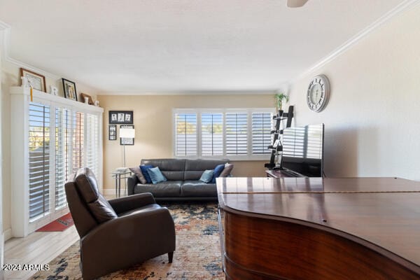 living room with crown molding, ceiling fan, and light hardwood / wood-style floors