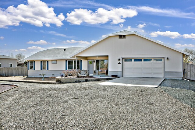 ranch-style home with a garage, driveway, and fence