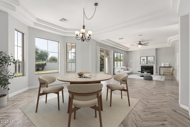 4497 E Carriage Way, Gilbert, AZ 85297 - dining room with a tray ceiling, baseboards, a chandelier, and a fireplace