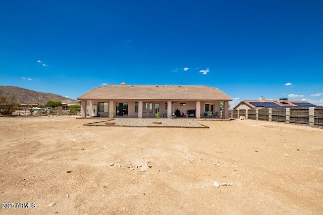 back of property with fence and a mountain view