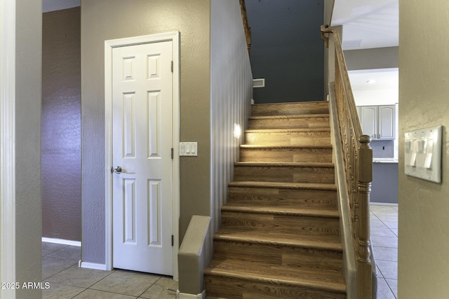 staircase featuring tile patterned flooring